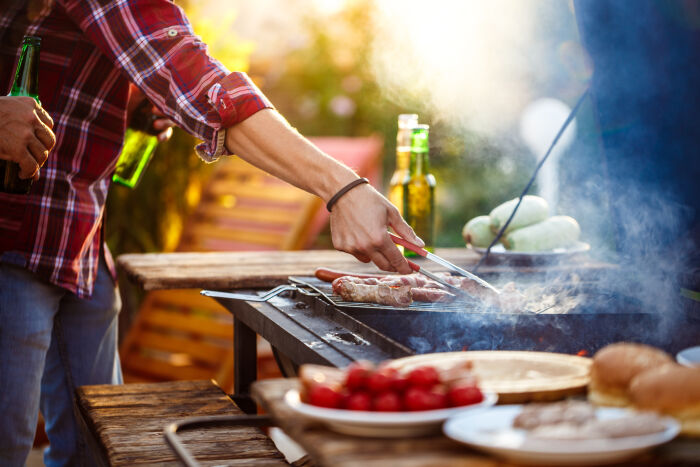 jeunes-hommes-rotir-le-barbecue-sur-le-grill-dans-la-campagne-du-chalet (1).jpg © cookie_studio - Freepik